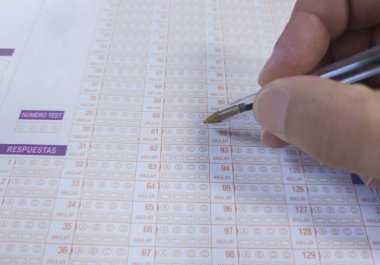 Aday el çoktan seçmeli sınavın üzerinde bir top tutuyor. Kamu incelemesi kavramı