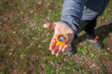 Elinde oyuncak pusula tutan çocuk. Çocuklar için doğada oryantasyon oyunları