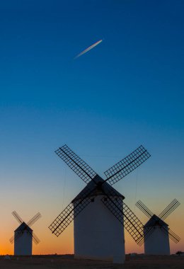 Airliner flying over old traditional windmills of Campo de Criptana, Castilla La Mancha (New Castile), Spain, Europe