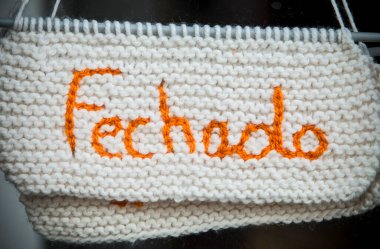 Closed sign in portuguese language. Crocheted crafts sign made