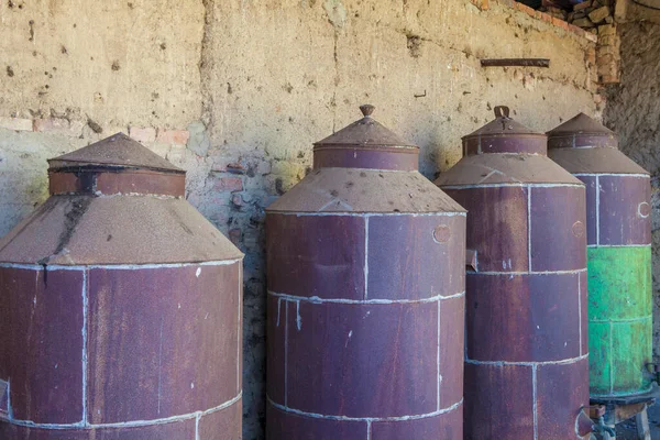 Rusty disused olive oil drums. Old farm background