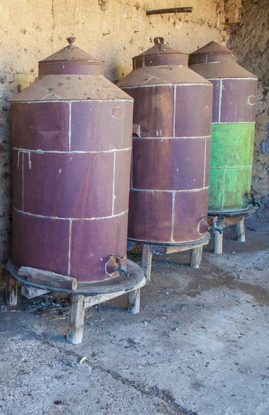 Rusty disused olive oil drums. Old farm background