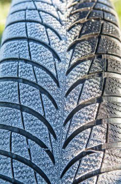 Frost covered tire surface. Safe driving on winter concept