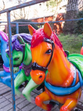Horses out of merry-go-round placed on line. Outdoors shoot