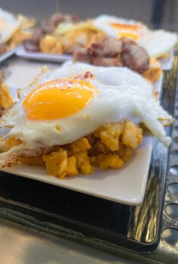 Scrambled potatoes with fried egg or patatas revolconas. Served at tapas bar desktop 