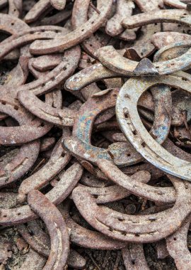 Pile of old used and rusty horseshoes. Selective focus