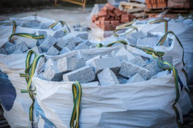 Raffia granit kaldırım taşlarıyla dolu büyük bir çuval. İnşaat malzemesi konsepti