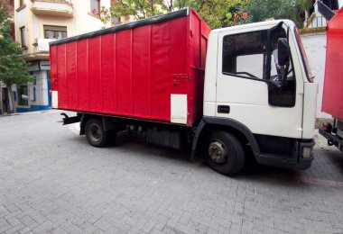 Şehir merkezine park edilmiş kırmızı yarı karavan kamyonları. İçecek dağıtım konsepti