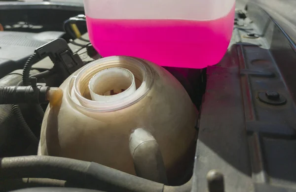 液体タンクに近い凍結防止剤のボトル 古いディーゼルエンジンの背景 — ストック写真