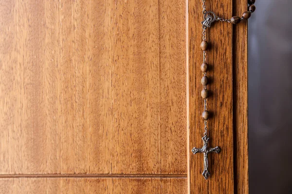 天主教的念珠挂在木门上 有选择的重点 — 图库照片