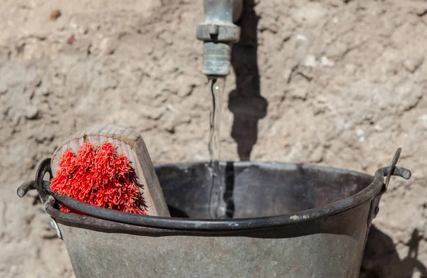 Çalı Çırpıyla Metal Bir Kovadan Musluk Doluyor Kırmızı Ovalama Fırçasına — Stok fotoğraf