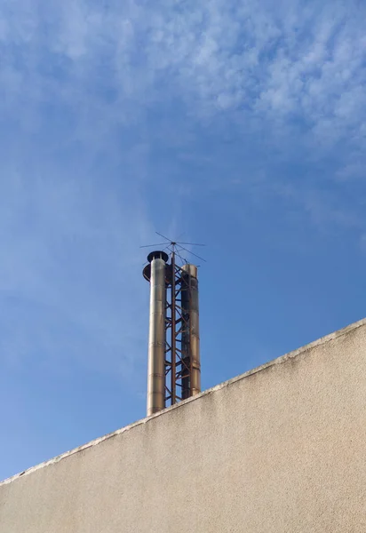 stock image Industrial chimney equipped with bird spikes. Blue sky background