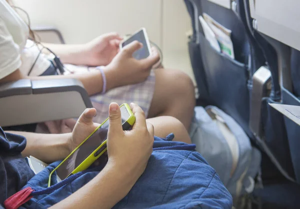 飛行中のスマートフォンでビデオを見ている子供たち 自分のエンターテイメントシステムを使用して若い航空機の乗客 — ストック写真
