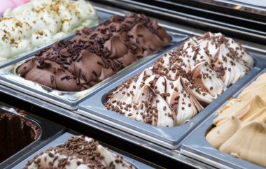 Display counter with assorted ice cream flavours. Selective focus clipart