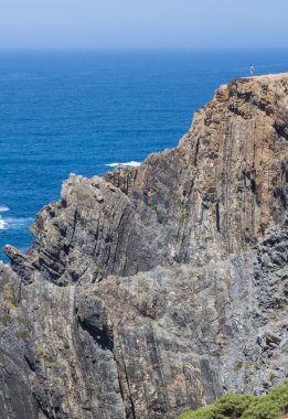 Cabo Sardao sahilinin tepesinden denizi izleyen ziyaretçi, Ponta do Cavaleiro, Sao Teotonio, Portekiz
