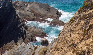 Beyaz leylek yuvası uçurumun tepesine kurulmuş. Cabo Sardao Sahili, Ponta do Cavaleiro, Sao Teotonio, Portekiz