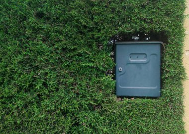 Kalın bir çitle gömülü dış posta kutusu. Yurt içi bahçe kavramı