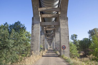 Acedera Aqueduct 'un altından geçen servis yolu. Orellana Sulama Kanalı, Vegas Altas del Guadiana, Extremadura, İspanya