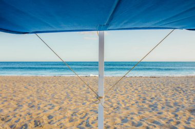 Arka planda okyanus olan tente yapısı. Plaj modası mobilya konsepti