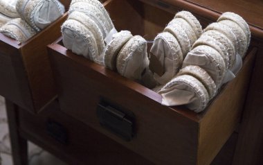 Beyaz espadrille ayakkabılarıyla dolu tahta çekmece. Düğün davetlileri için tek kullanımlık ayakkabılar.