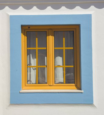 Vila Nova de Milfontes 'in evinde parlak renklerle boyanmış küçük bir pencere. Portekiz 'in Alentejo kıyısındaki küçük pitoresk kasaba.