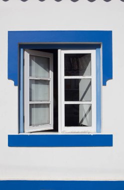 Vila Nova de Milfontes 'in evinde parlak renklerle boyanmış küçük bir pencere. Portekiz 'in Alentejo kıyısındaki küçük pitoresk kasaba.