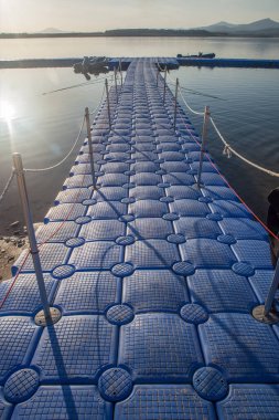 Tırabzanlardan sarkan denizcilik kıyafetleri olan modüler duba. Gabriel y Galan rezervuarı, Caceres, İspanya