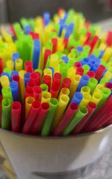 Plastic drinking straws displayed over bar countertop. Selective focus