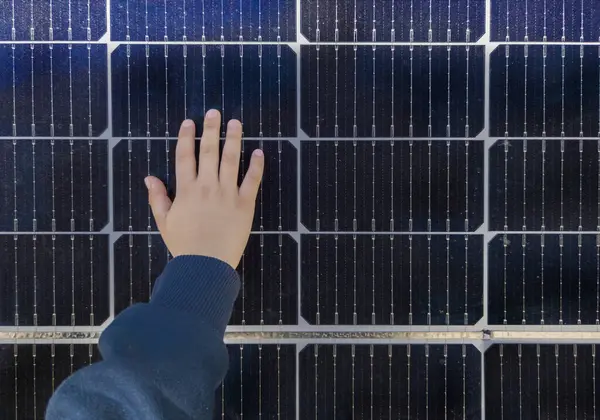 Child boy touching solar panel surface. Environmental education on renewable energies