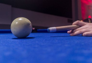 Oyuncu bilardo topuna vurmak üzere. Sekiz top bilardo oyunu