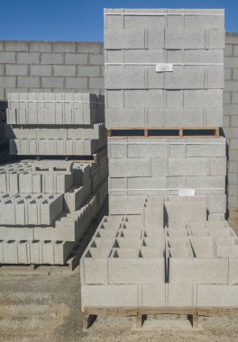 Alçılamak için tam boy beton bloklar. Tahta paletlerin üzerine istiflenmiş