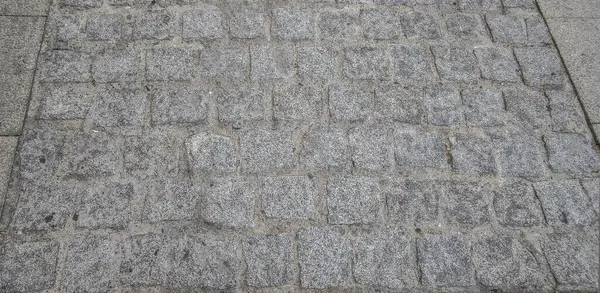 Sett pavement made with quarried granite cubic blocks without roughing. Monumental Complex road surfaces, Caceres, Spain