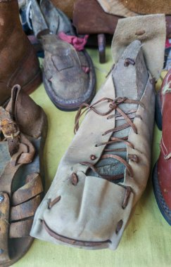 Geleneksel kordwainer masasında eski ayakkabılar sergileniyor. Eski kunduracılar atölyesi