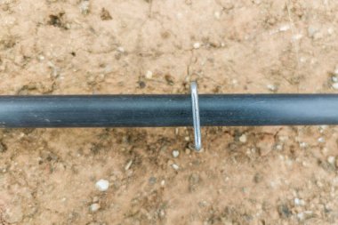 U pimleri ya da boruların üzerine asılmış çivileri tutun. Damla sulama için bahçe malzemeleri