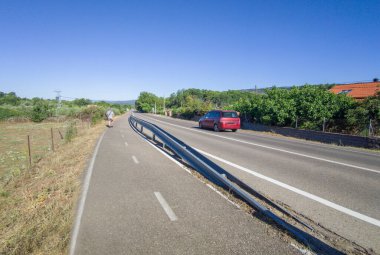 Yerel bir yola paralel giden ayrık bisiklet yolu. Yaya yürüyüşü