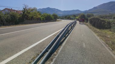 Segregated cycle lane running parallel to a local road. Pedestrians walking clipart