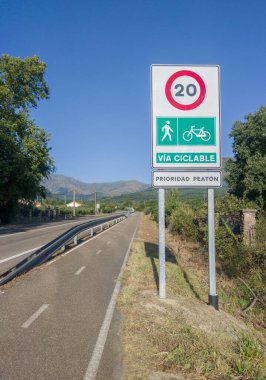 Hervas, İspanya - 24 Temmuz 2024: Yerel bir yola paralel giden ayrık bisiklet yolu. Trafik işaretleri trafiği bisikletçiler ve yayalarla sınırlıyor