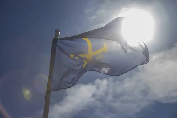 stock image Principality of Asturias flag fluttering in a brisk breeze against the light