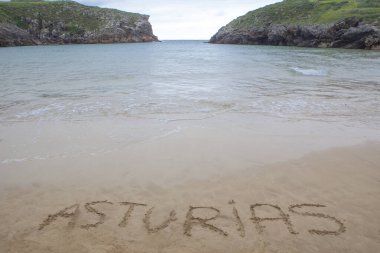 Guadamia Sahili, Bufones de Pria, Llames, Asturias, İspanya. Kumun üzerinde Asturias yazıyor.