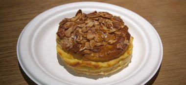 Pantxineta beyaz plaka üzerinde ahşap zemin üzerinde sergilenmektedir. Bask ülkesinin tipik tatlısı.