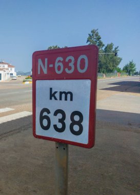 Badajoz, Spain - June 14th, 2018: 638 kilometer of Spanish National N-630 Road. Urban sing post clipart