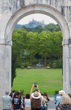 Sintra, Portekiz, 8 Ağustos 2024: Seteais Palace kemeri, Sintra, Portekiz 'den Palacio da Pena' yı gözlemleyen ziyaretçiler. Büyük Lizbon Bölgesi 'nin başlıca turizm beldesi
