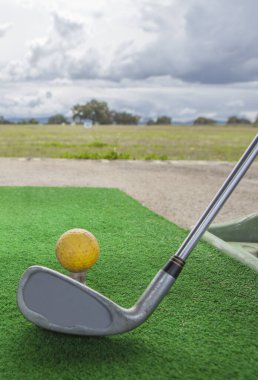 Golf yeni başlayanlar için golf sahası. Sarı top ve golf sopası ile golf hasırı