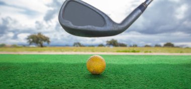 Golf yeni başlayanlar için golf sahası. Sarı top ve golf sopası ile golf hasırı