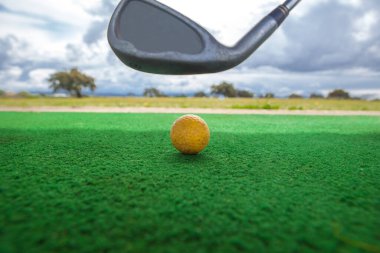 Golf yeni başlayanlar için golf sahası. Sarı top ve golf sopası ile golf hasırı