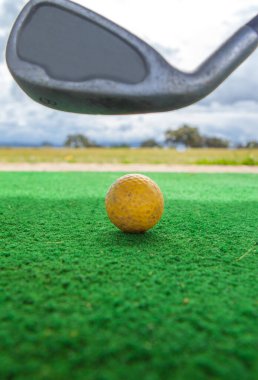 Golf yeni başlayanlar için golf sahası. Sarı top ve golf sopası ile golf hasırı