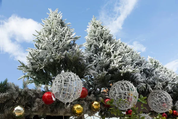 Árvores Natal Polvilhadas Com Neve Bolas Guirlandas Contra Céu Azul — Fotografia de Stock