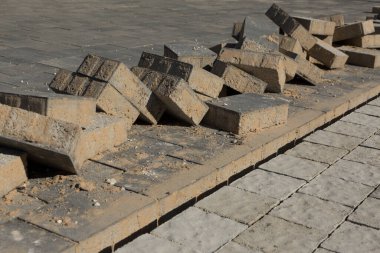 In the process of building a street sidewalk where a pile of stacked laying bricks