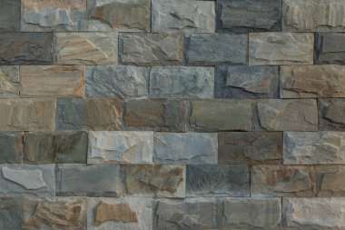 Soğuk ve sıcak gölgeli güzel bir dokusu olan doğal dikdörtgen taşla kaplı bir duvar.