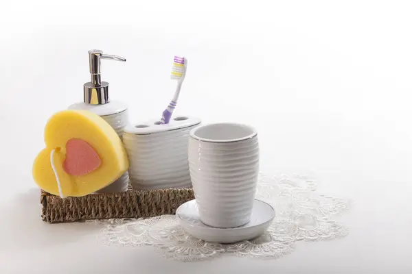 陶瓷容器里的牙刷 液体肥皂瓶 篮子里的海绵 洗嘴用的杯子和茶托 — 图库照片
